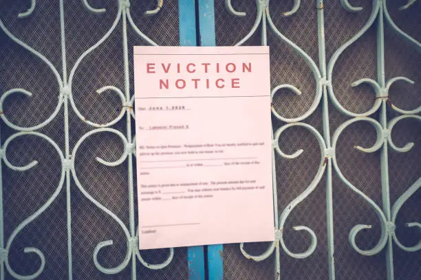 Photo of Foreclosed or eviciton notice on a main door with blurred details of a house with vintage filter.