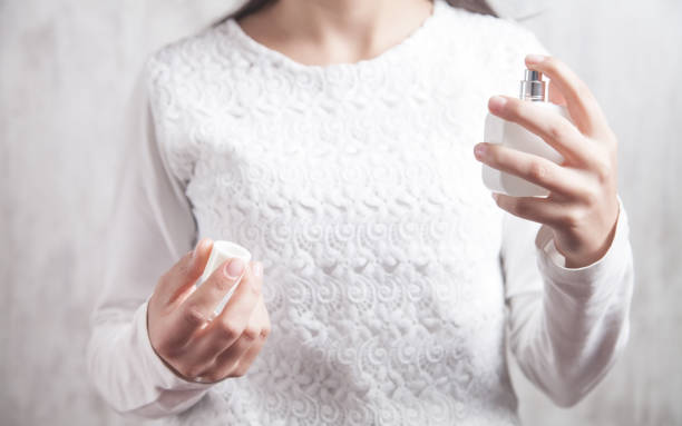 istock Girl holding bottle of perfume. 1253982172