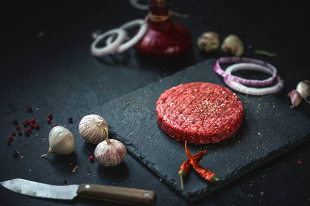 istock Minced beef burgers with spices and ingredients 1253986410
