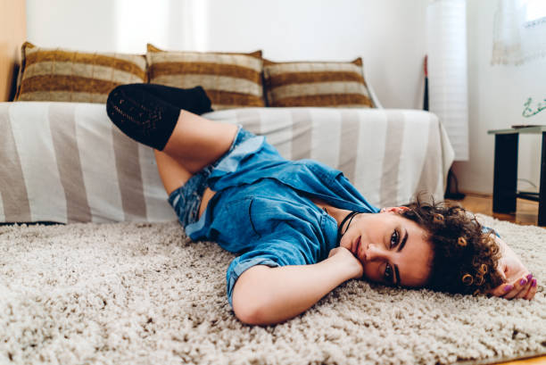 istock Attractive young woman lying on carpet 1253991037