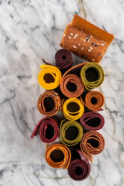 sweet pure fruit pastille on a marble board. natural sweets from berries and fruits in rolls. useful sweets are pastilles, fruit chips. dietary vitamin nutrition. vegan food. - pastilles imagens e fotografias de stock