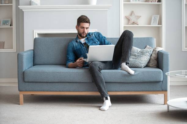 istock Handsome modern man designer working on laptop online, using internet at home 1253992315