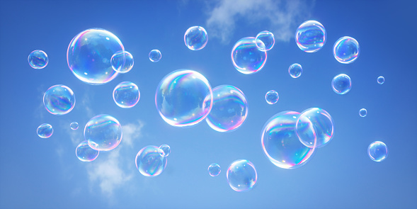 Lots of soap bubbles flying through the air with clear blue sky background