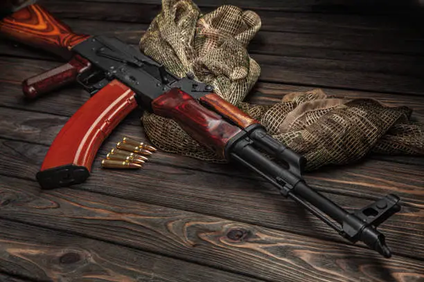 Photo of Classic Soviet AK machine gun on a wooden background. Weapons of Russia and the Soviet Union.