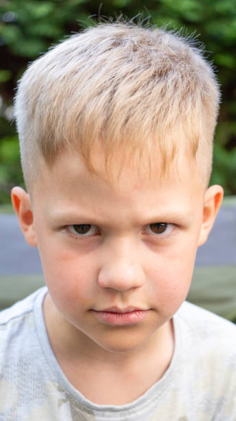 istock Sad and unhappy boy looking into camera. Spoiled, arrogant, and annoyed child concept. 1253997286