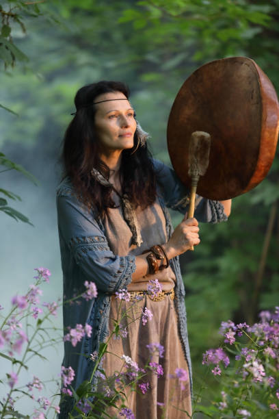 istock Shaman woman drumming in the evening forest 1253999096