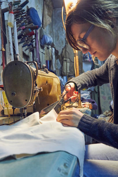 istock Woman tailor using retro sewing machine at home, hobby concept. 1253999282