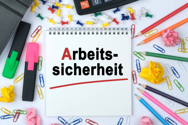 istock On the table is a calculator, diary, markers, pencils and a notebook with the inscription - Arbeits-sicherheit 1254002445