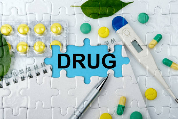 istock Double exposure. Puzzles with the image of tablets, a notebook, a thermometer and a pen with the inscription -DRUG 1254002453