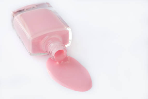 Spilled nail polish in a glass bottle on a white background, pink enamel for french manicure. Cosmetic product. Empty place for text. Copy space, mockup. stock photo