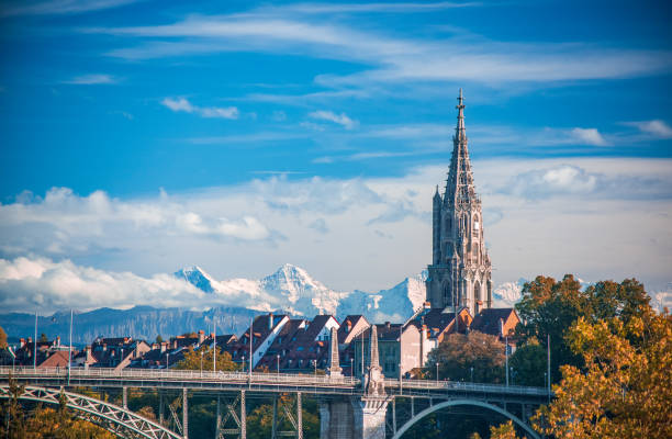 Scenic view of tower of Munster cathedral in Bern, Switzerland Scenic view of tower of Munster cathedral in Bern, Switzerland. Snowcaped alpine peaks on background. Picturesque sky. UNESCO World Heritage Site bern photos stock pictures, royalty-free photos & images