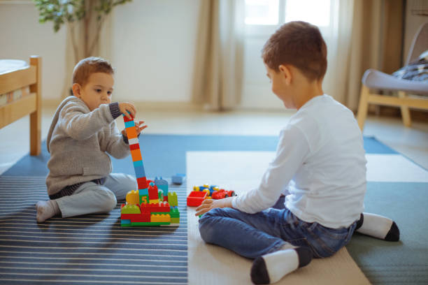 istock Siblings playing with toy blocks on the floor 1254010795