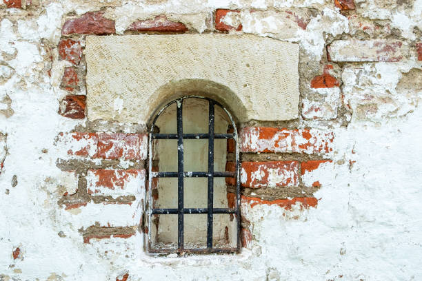 istock Fragment of an old brick wall with a small window 1254011048