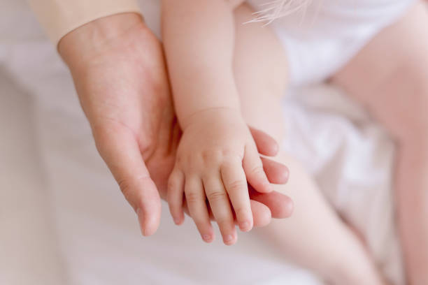 istock little baby hand in mom's hand 1254011075