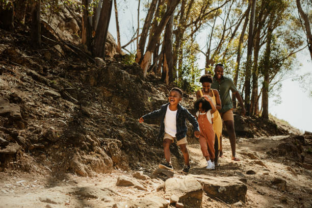famiglia che corre lungo il sentiero roccioso - vacanza foto e immagini stock