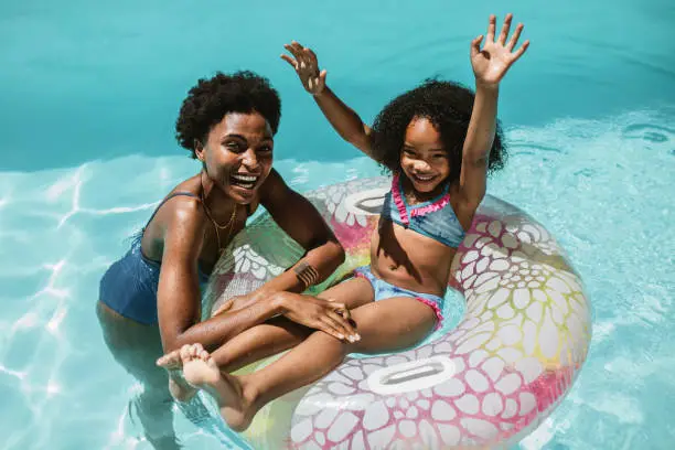 Photo of Mother and daughter enjoying summer holidays in pool