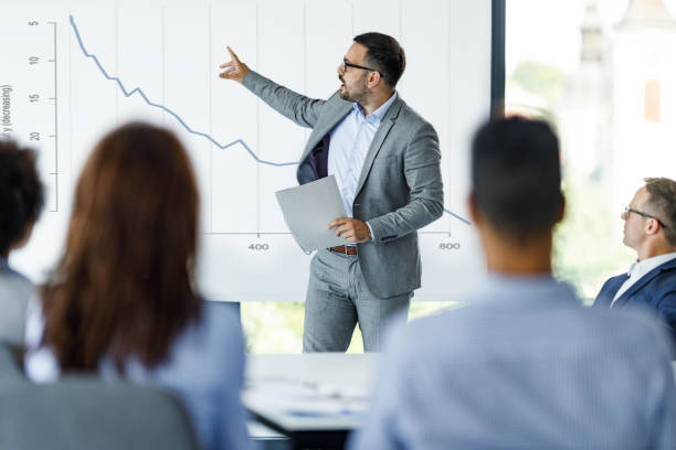 istock Male CEO talking about economic crisis on presentation in the office. 1254014659