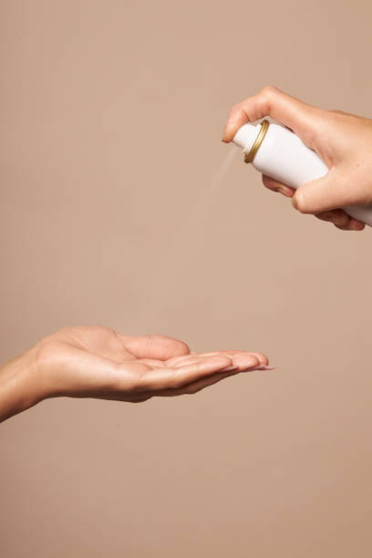 istock Hygiene female hands using an antiseptic spray on a beige background. Use a quality product to maintain good health. 1254014736