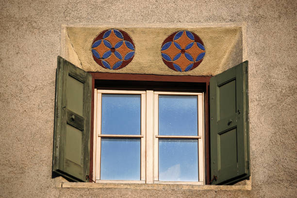 antigua ventana de madera con decoraciones - guarda pueblo engadina suiza - engadine rustic window frame window sill fotografías e imágenes de stock