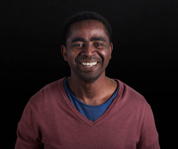 istock Mid adult man standing against black background 1254014886