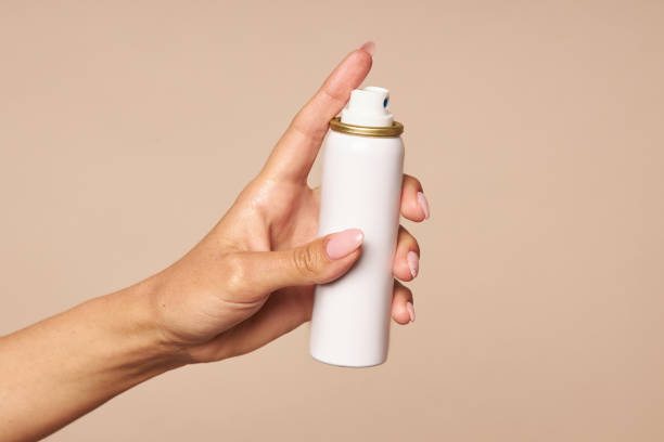 istock Hand hygiene spraying an antiseptic on a beige background. Using Sanitizer for Virus Prevention and Health 1254016178