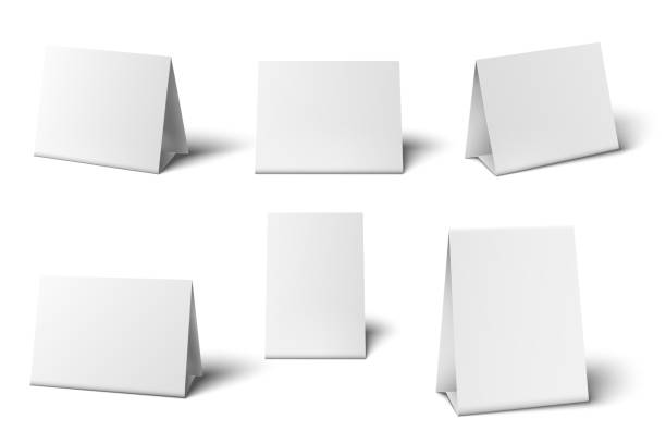 istock White table card mockup. Standing blank paper banners, greeting cards restaurant menu 3d vector isolated template set. 1254016285