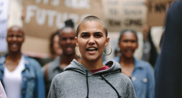 istock Woman protesting with a group of people 1254016404