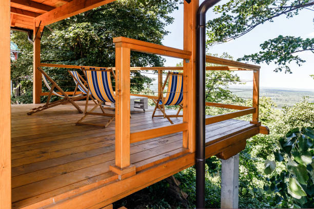 Balcony with deck chairs and table among greenery.