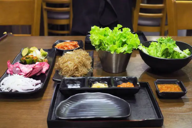 Photo of Korean grill pork belly BBQ (Samgyeopsal Gui) - trendy Korean barbecue dish, served with fresh vegetable and dipping sauce.