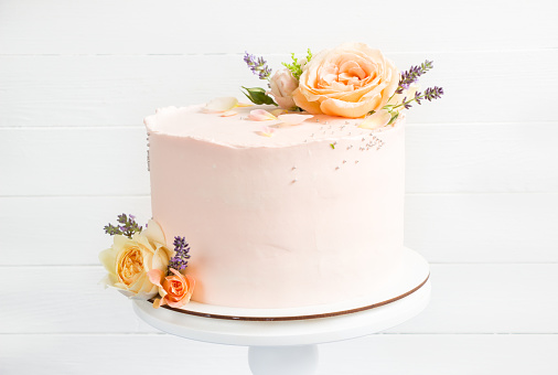 Beautiful roses cake on vintage stand. Peach roses and lavender cake, Concept for Wedding , St. Valentine's Day, Mother's Day, Birthday Cake. White background