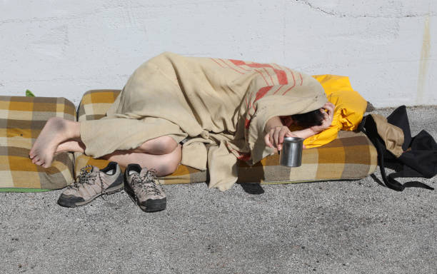 istock homeless man asks for alms while resting on a filthy mattress 1254018720