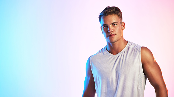 Studio portrait of a handsome young male athlete posing against a multi-coloured background