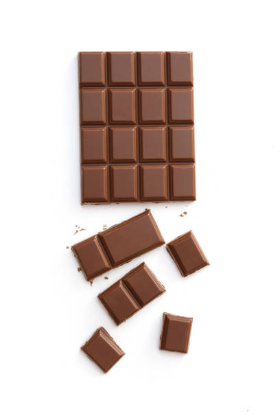 Milk chocolate pieces isolated on white background from top view