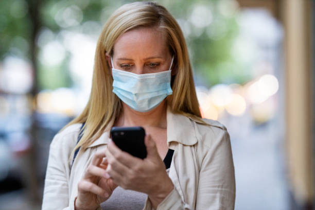 istock Woman with mask texting on her phone during commute 1254026664