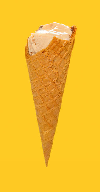 istock side view milk tea flavor ice cream cone with some bites on a yellow background 1254027150