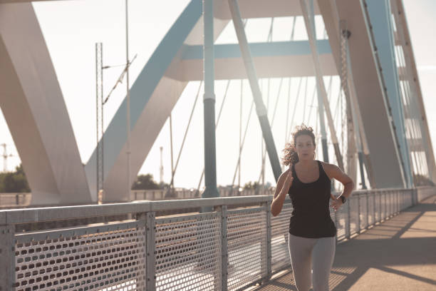 istock Young woman running at the Bridge 1254028268