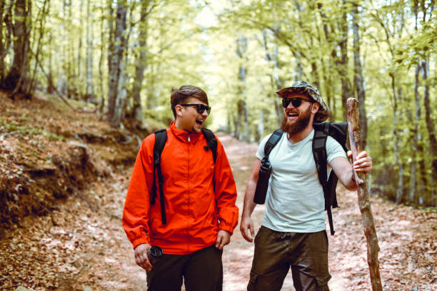 istock Laughing Hikers Easing Their Trip With Jokes In Forest 1254030299