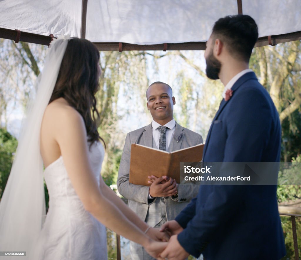 I now pronounce you husband and wife Shot of a happy young couple getting married in a garden Wedding Stock Photo