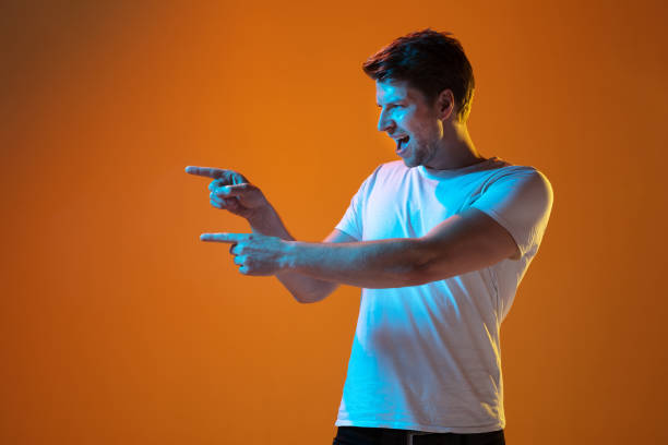 istock Caucasian beautiful young man's portrait on gradient orange studio background, emotional and expressive. Copyspace for ad. 1254036701