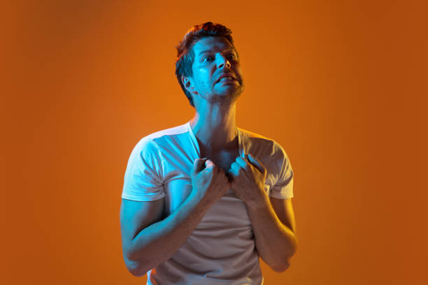 istock Caucasian beautiful young man's portrait on gradient orange studio background, emotional and expressive. Copyspace for ad. 1254036713
