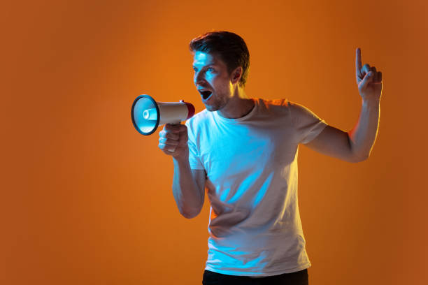 istock Caucasian beautiful young man's portrait on gradient orange studio background, emotional and expressive. Copyspace for ad. 1254036716