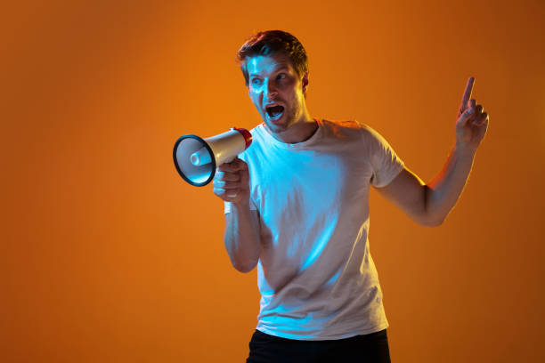 istock Caucasian beautiful young man's portrait on gradient orange studio background, emotional and expressive. Copyspace for ad. 1254036719