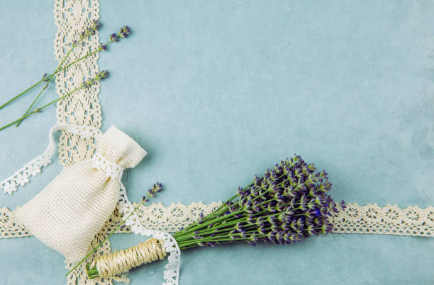 istock Top view blue patterned background surrounded by bundle of fresh lavender branches and scented dry lavender bag with cotton lace. Romantic vintage background concept. 1254037798