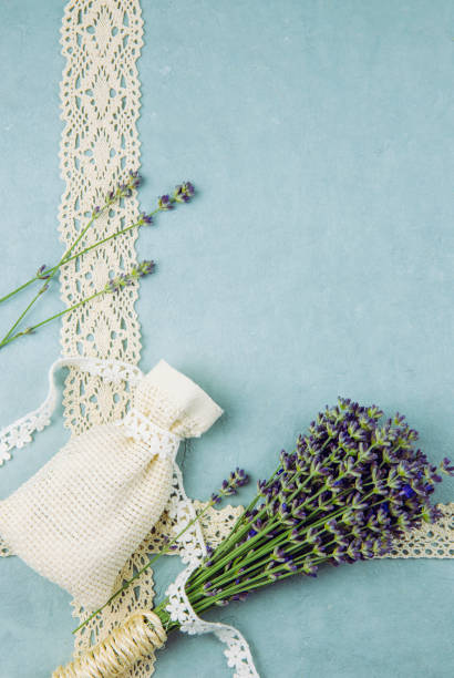 istock Top view blue patterned background surrounded by bundle of fresh lavender branches and scented dry lavender bag with cotton lace. Romantic vintage background concept. 1254037801
