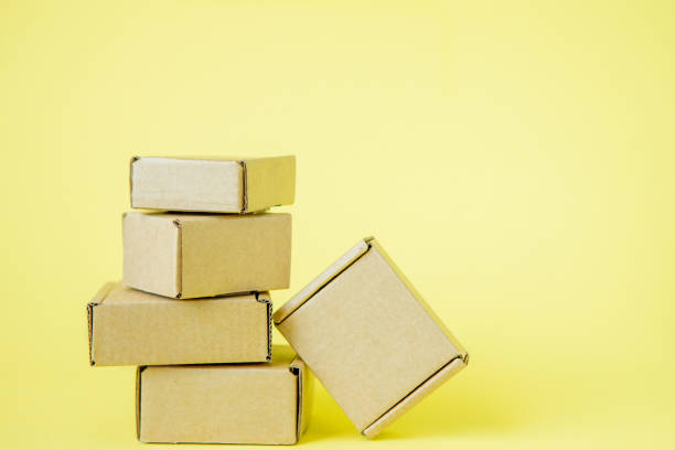 istock Cardboard boxes of various sizes on yellow background. 1254037844
