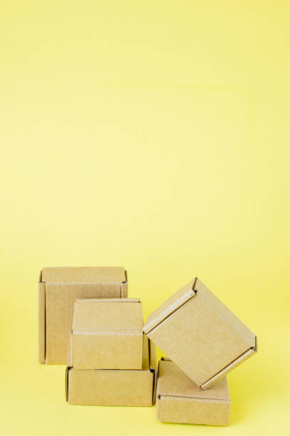 istock Cardboard boxes of various sizes on yellow background. 1254037854