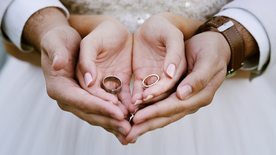 Cropped shot of a couple holding their wedding rings after getting married