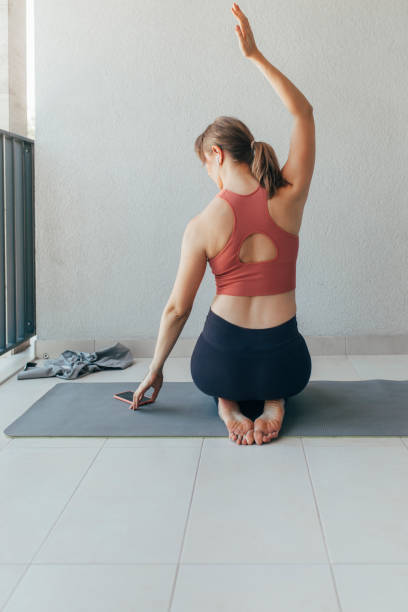 istock Beautiful Fit Woman Using her Mobile Phone to Work Out at Home 1254038199