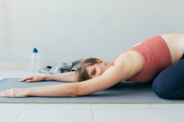 istock Healthy Lifestyle: a Beautiful Woman Doing Relaxing Yoga Exercise at Home, Looking at Camera 1254038241