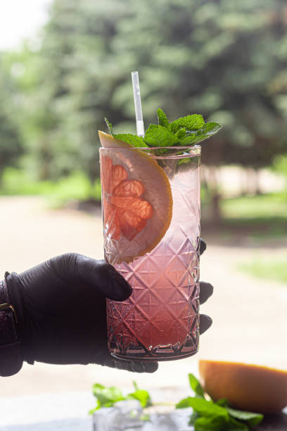 istock A refreshing summer cocktail with a slice of grapefruit. Alcoholic drink Paloma. Decorated with a sprig of mint and ice cubes. 1254039938